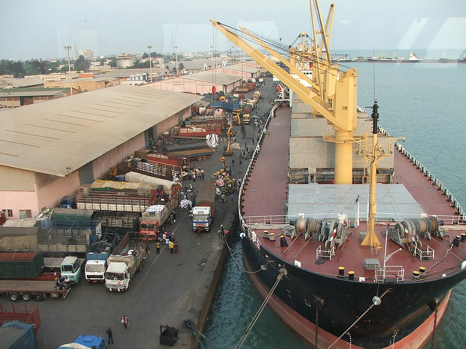 General cargo being handled beside a ship and trucks at the port of Cotonou.