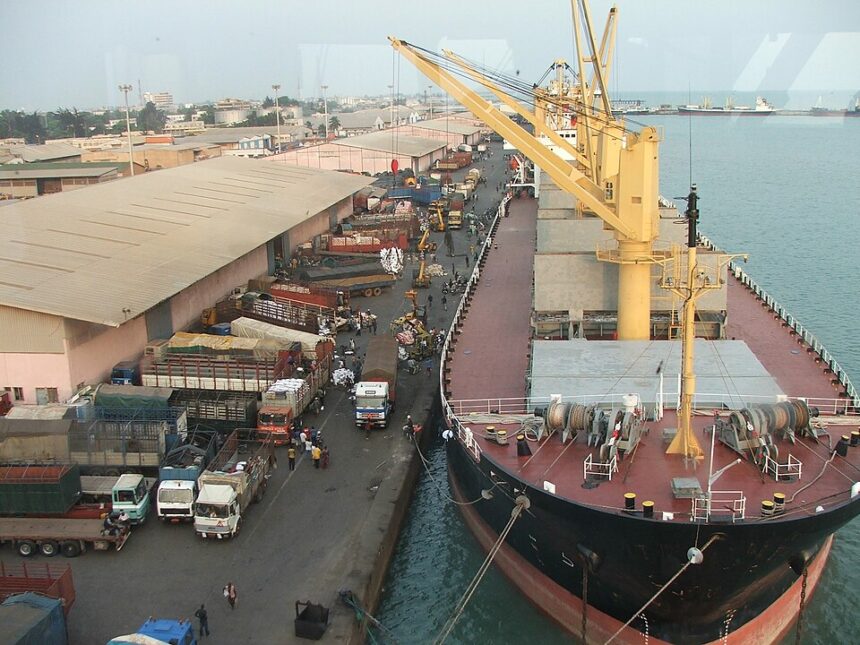 General cargo being handled beside a ship and trucks at the port of Cotonou.